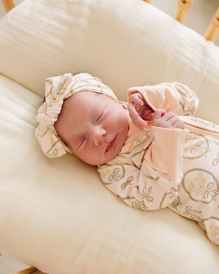 Bamboo head wrap on newborn, cream with gold bow print and gathered knot