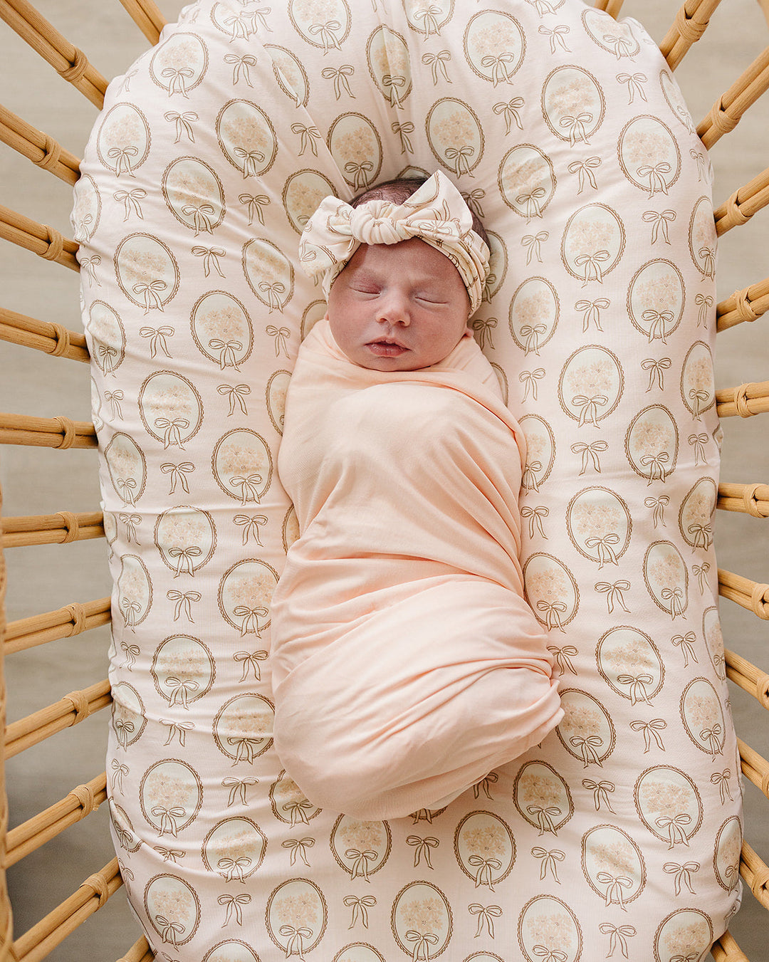 Bamboo head wrap on baby, cream all-over gold bow print with tied knot