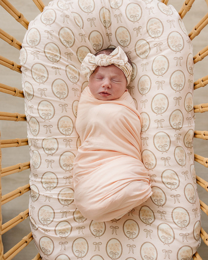 Bamboo head wrap on baby, cream all-over gold bow print with tied knot