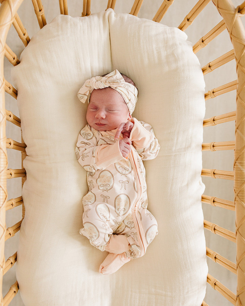 Cream patterned baby sleeper with front zipper and matching cap