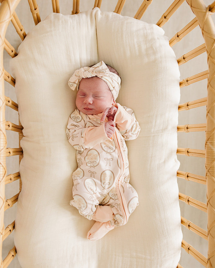 Cream patterned baby sleeper with front zipper and matching cap