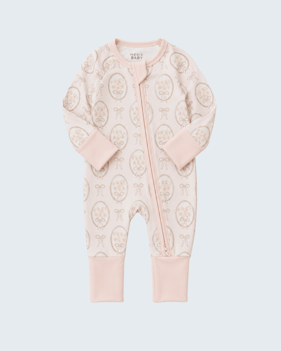 A baby long-sleeve footless one-piece sleeper in pale pink, featuring an all-over beige paisley pattern and a front zipper closure, shown on a light gray background.