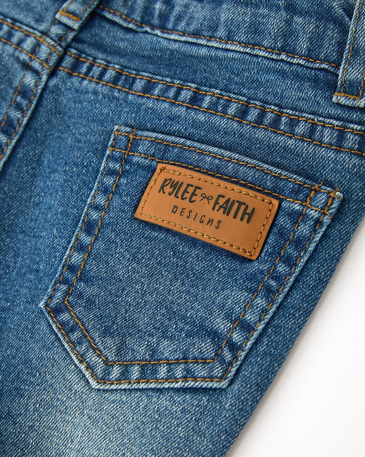 Blue denim jeans close-up of stitched back pocket with leather brand patch
