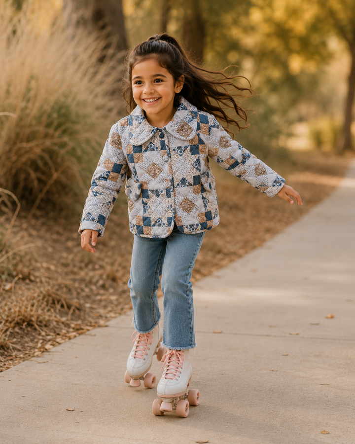 Young girl on roller skates wearing a patchwork jacket and jeans