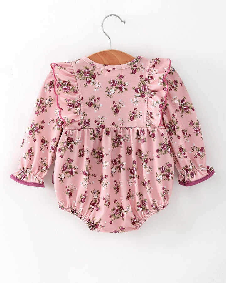Pink floral baby romper with long sleeves and purple bow at front