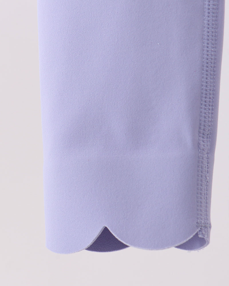 Close-up of a light purple garment with a textured pattern on a beige background