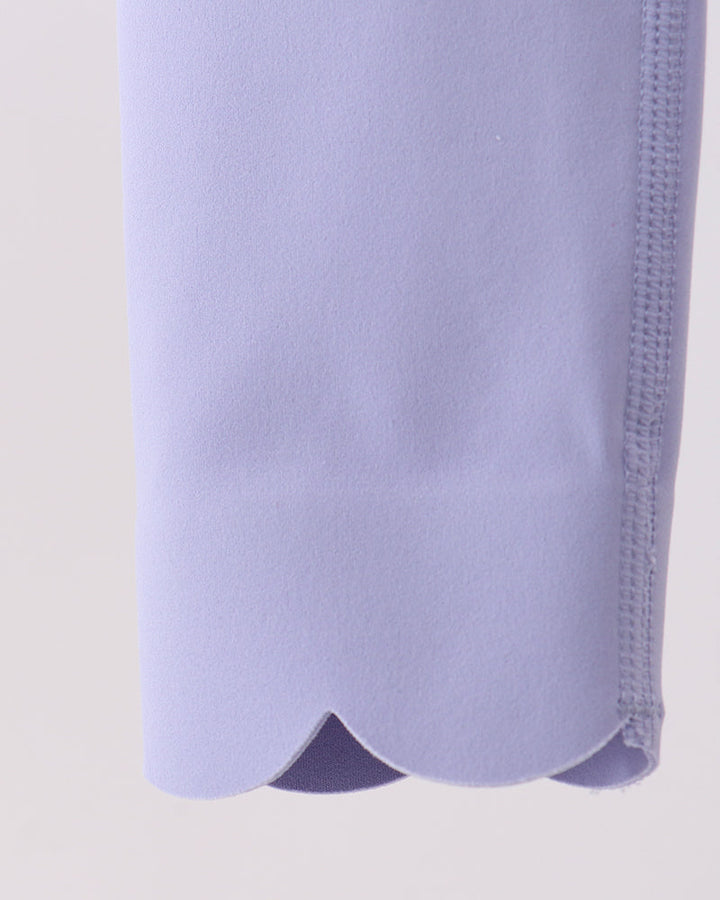 Close-up of a light purple garment with a textured pattern on a beige background