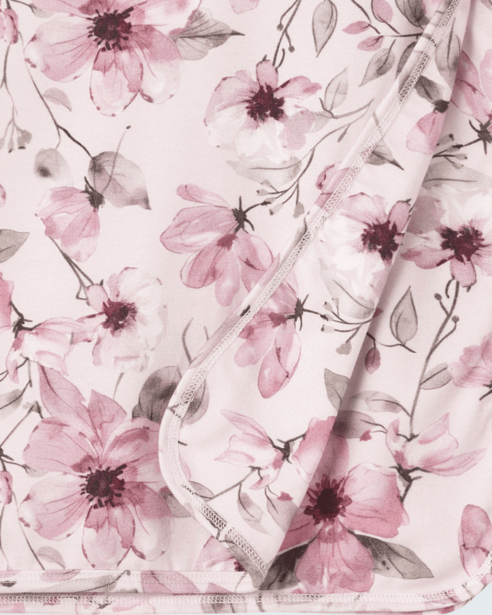 Bamboo baby blanket close-up with watercolor floral print and stitched edge trim