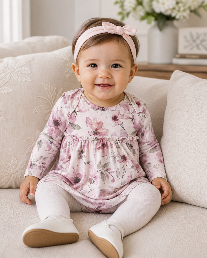Pink watercolor floral long-sleeve bodysuit with ruffled skirt overlay, front view