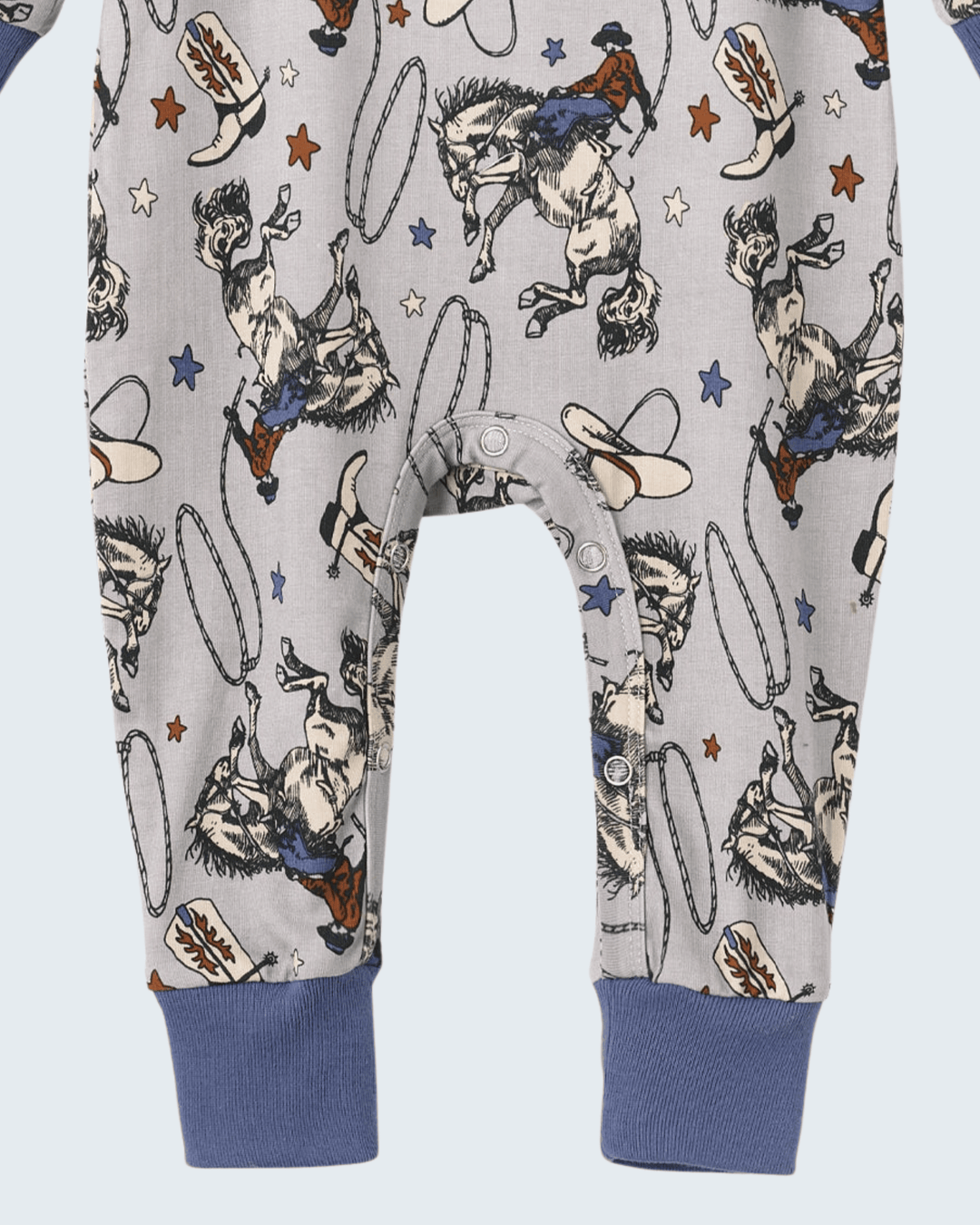 Cowboy print bamboo romper with front buttons and navy ribbed cuffs on long legs