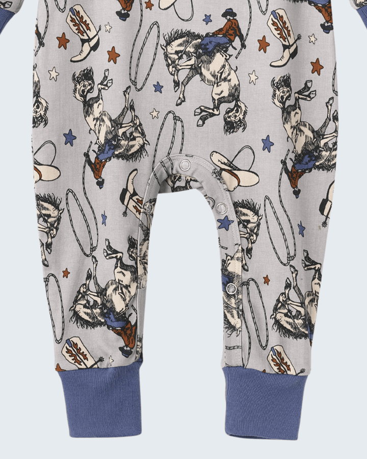 Cowboy print bamboo romper with front buttons and navy ribbed cuffs on long legs