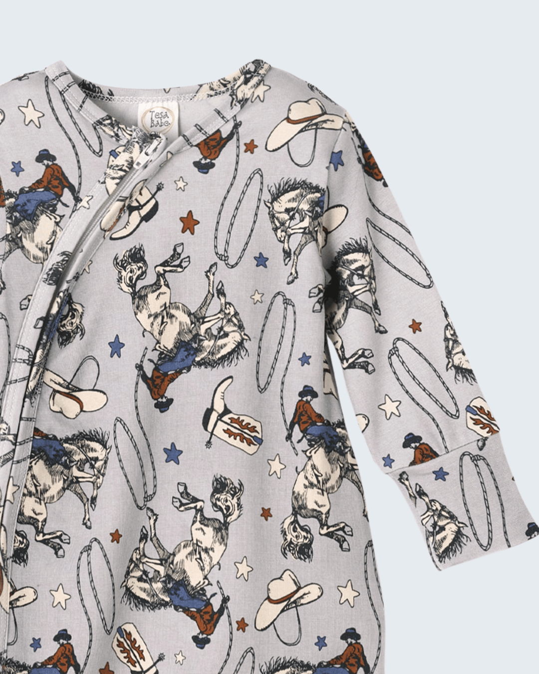 Light gray western romper with long sleeves, rodeo cowboys, horses, hats, and stars print