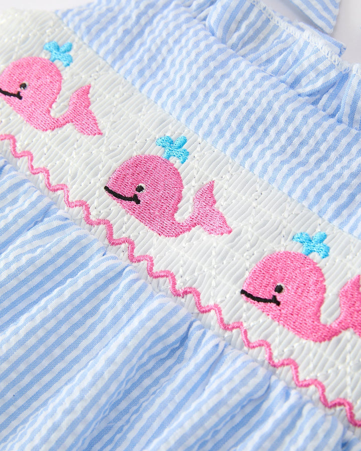 Baby romper with pink whale design on blue and white striped fabric