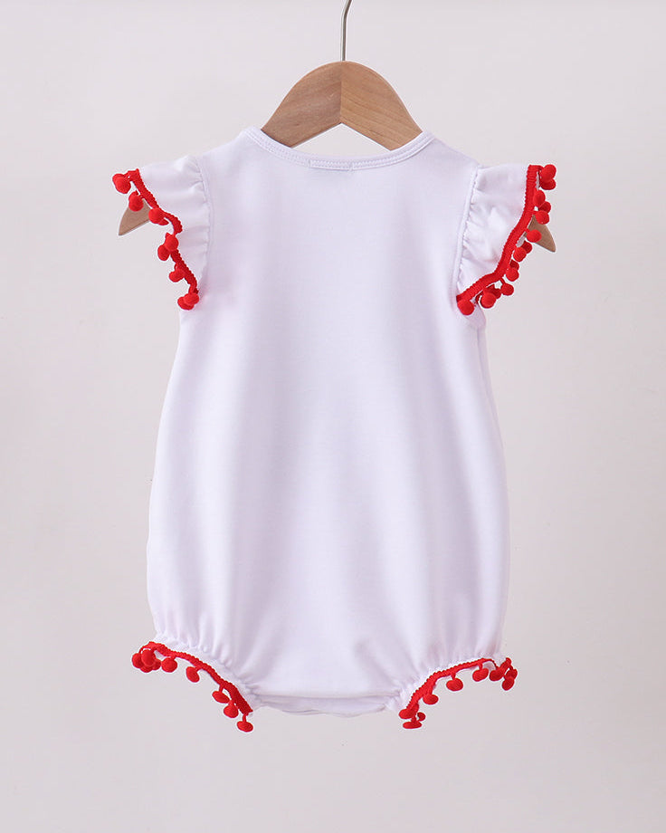 White baby romper with red trim on a wooden hanger against a beige background
