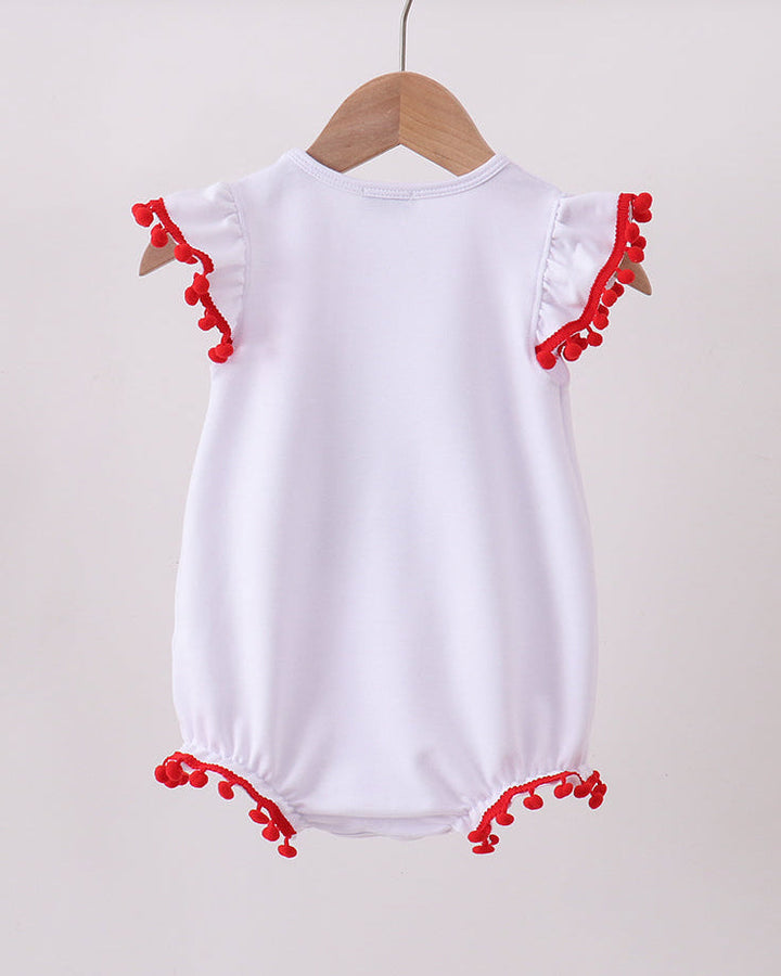 White baby romper with red trim on a wooden hanger against a beige background
