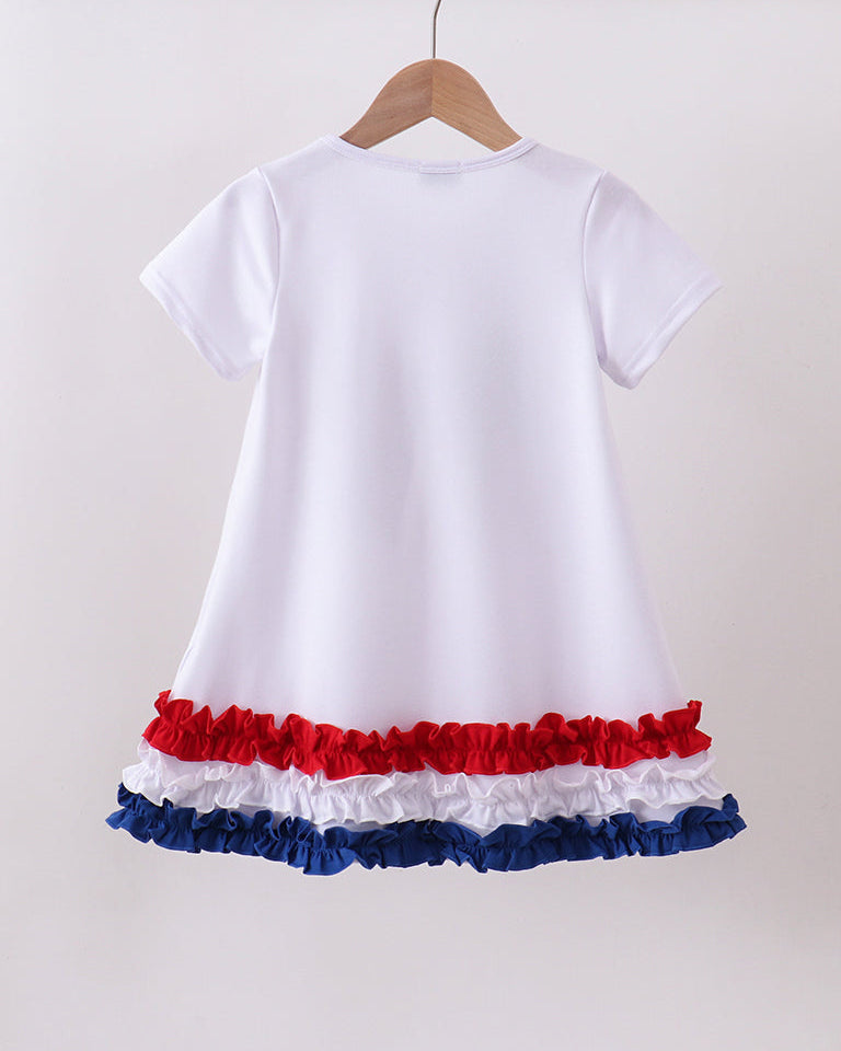 White dress with red and blue ruffled hem on a hanger against a white background