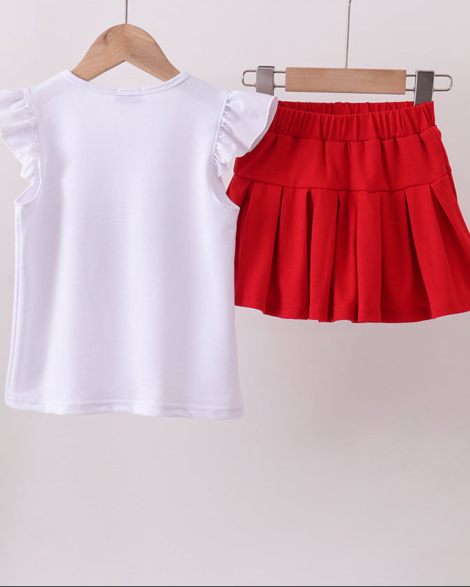 White t-shirt and red pleated skirt on hangers against a white background