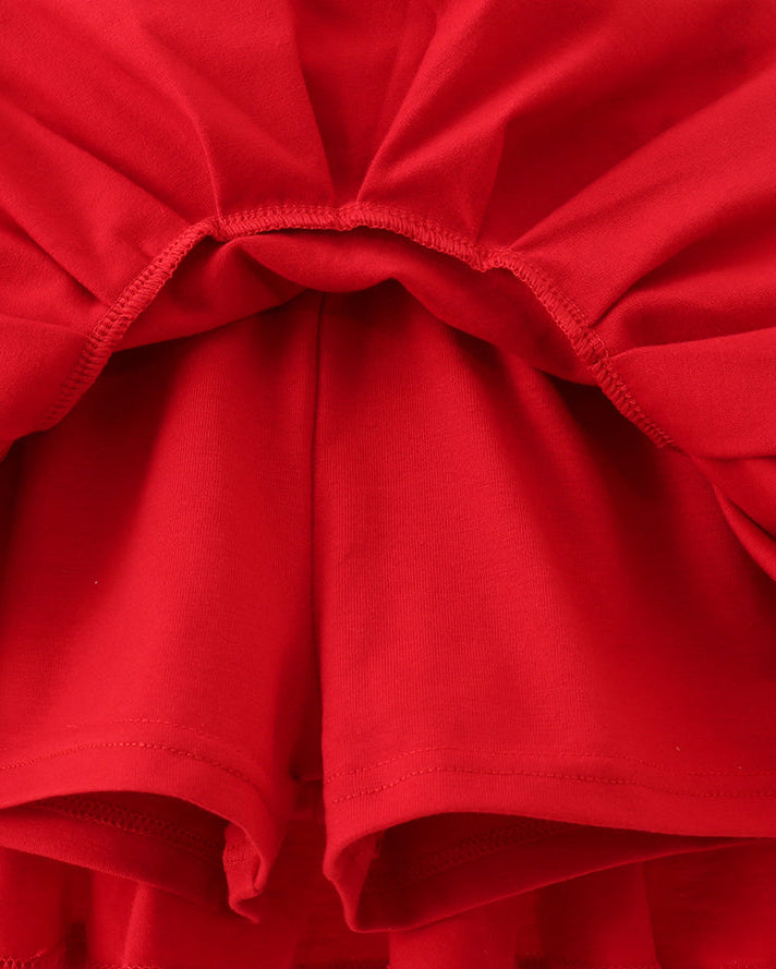 Close-up of a red skirt with ruffled layers on a light gray background