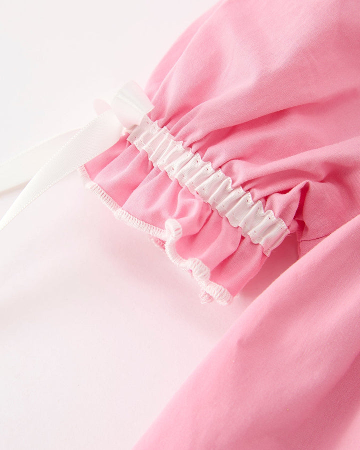 Girls pink long-sleeve dress with ruffled elastic cuff and white bow accents
