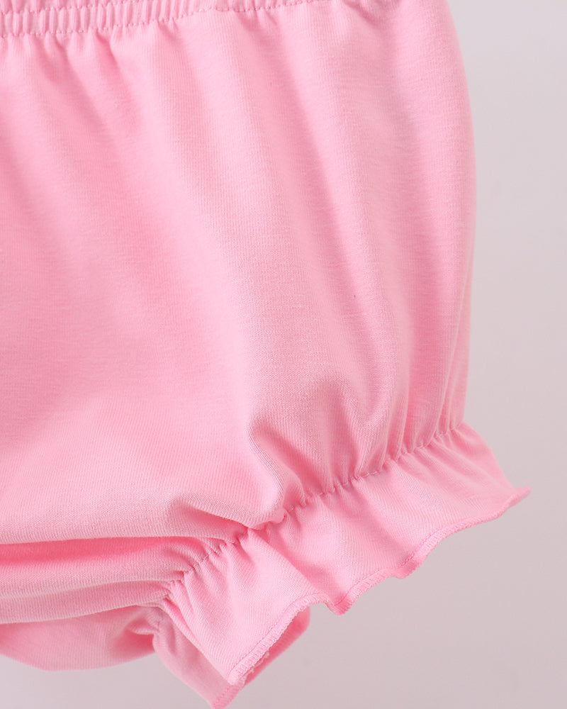 Pink elastic-waist bloomer shorts with ruffled hem and bow-tie accents