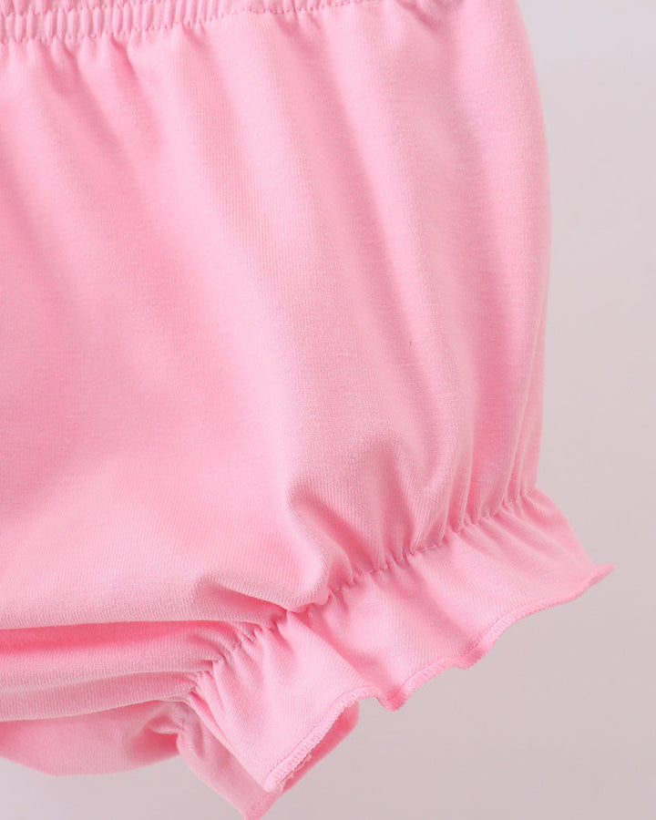 Pink elastic-waist bloomer shorts with ruffled hem and bow-tie accents