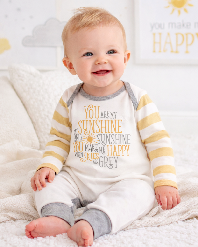 Baby romper in white with sunshine graphic, gray cuffs, and tan-striped sleeves