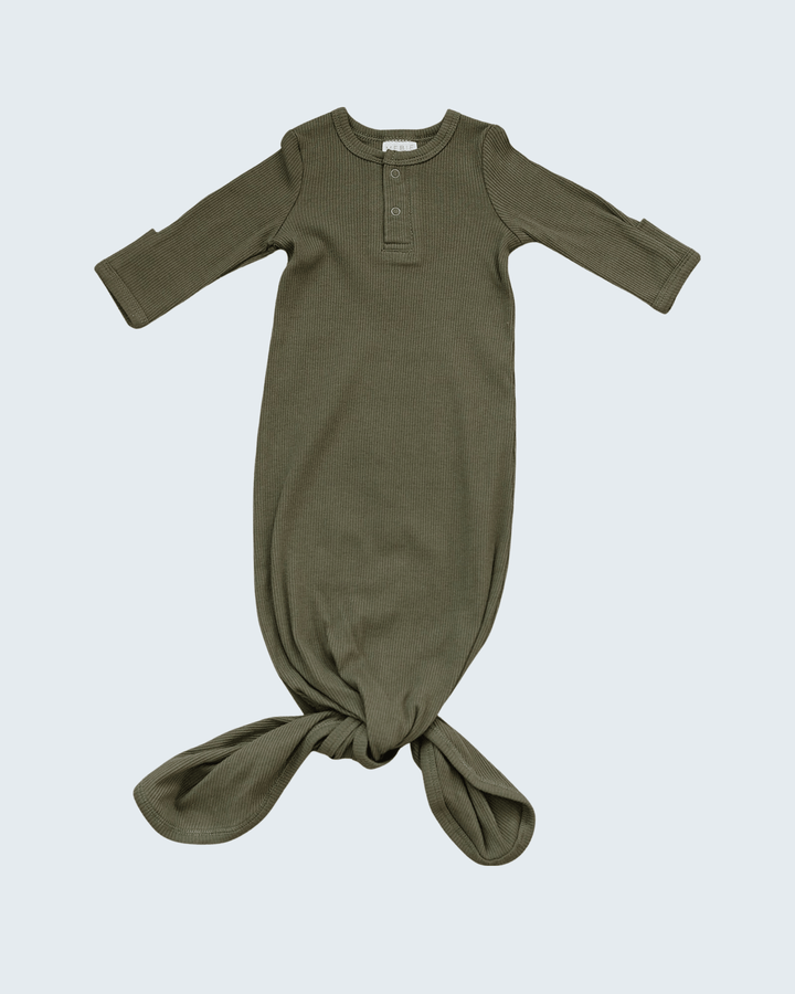Green baby gown with long sleeves on a light gray background