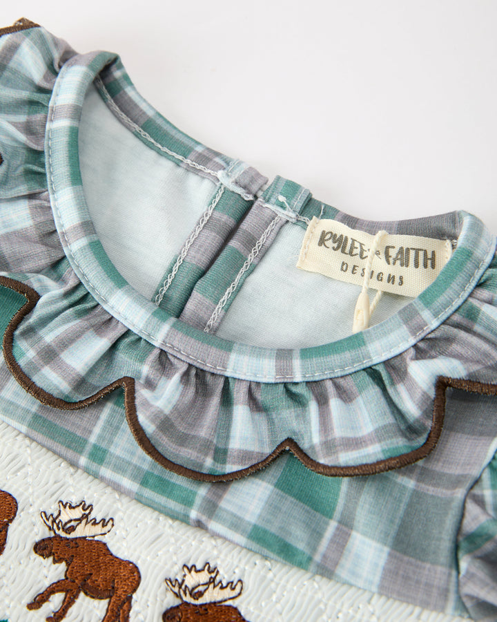 Green-and-white plaid baby romper with ruffle neckline and Rylee + Faith tag
