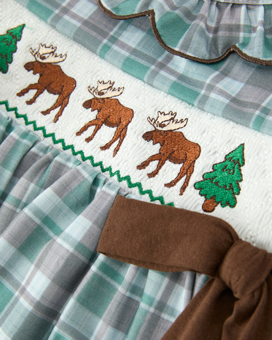 Moose and pine embroidery on girls plaid dress with brown waistband and gathered skirt