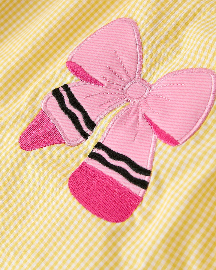 Pink crayon design on a yellow checkered fabric