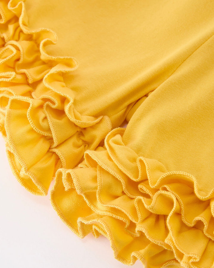 Close-up of yellow fabric with ruffled edges on a white background