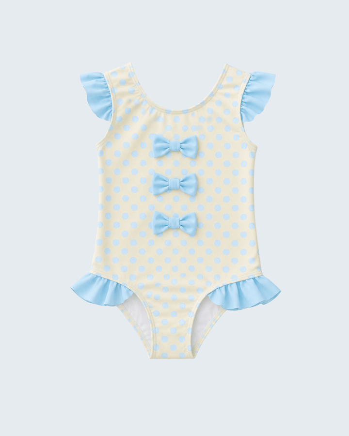 Yellow swimsuit with blue polka dots and ruffles on a light gray background