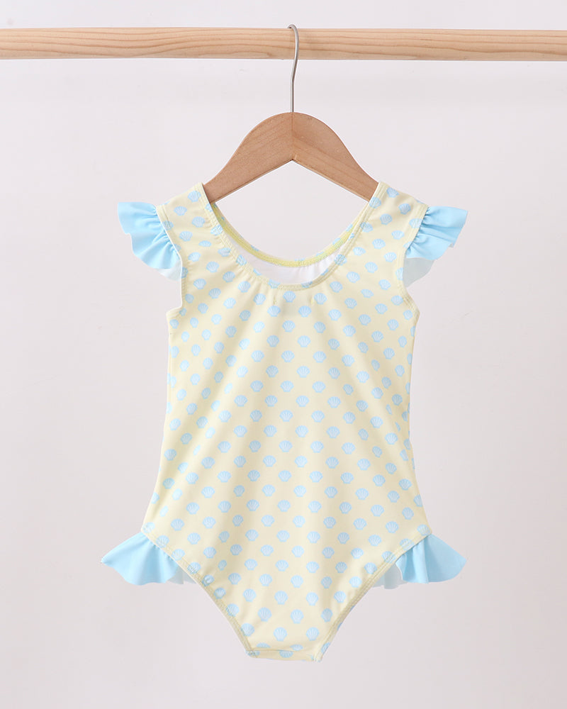 Yellow polka dot swimsuit with blue trim on a wooden hanger against a white background