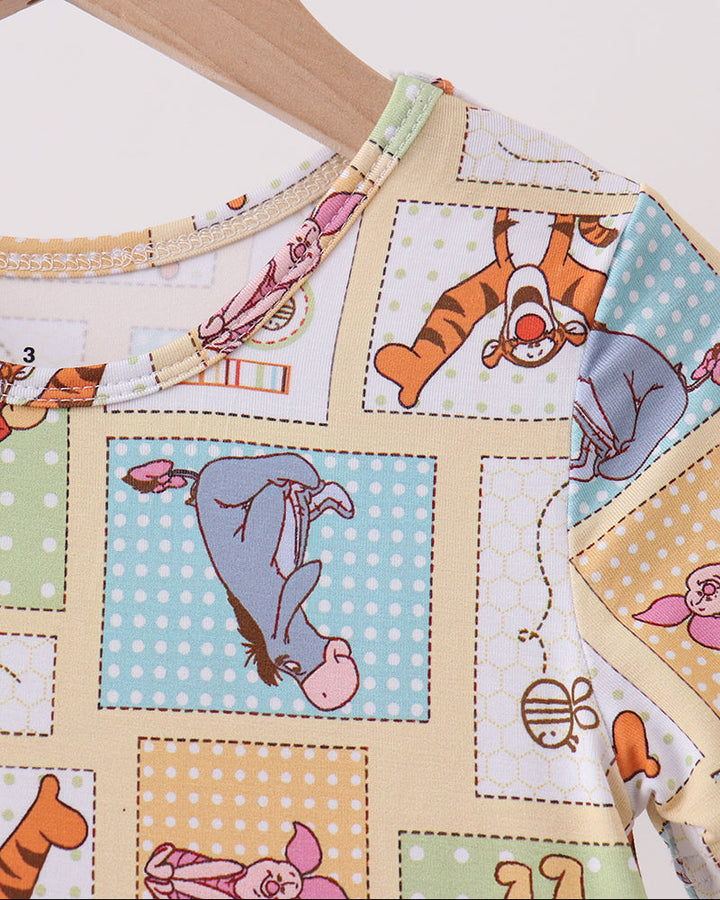 Bamboo dress close-up with Winnie the Pooh patchwork print and stitched neckline trim