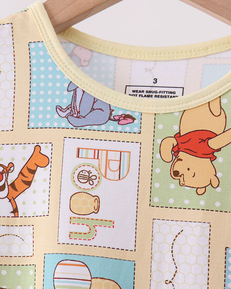 Bamboo pajama top neckline with yellow trim and Pooh-themed patch pattern print