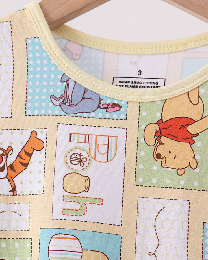 Bamboo pajama top neckline with yellow trim and Pooh-themed patch pattern print
