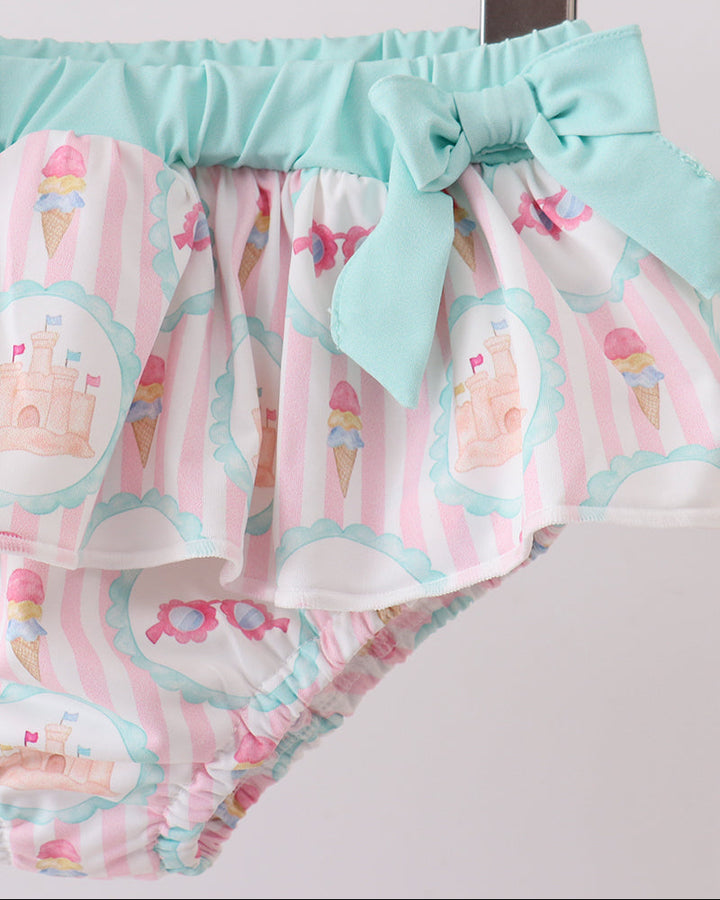 swimsuit bottoms with ice cream pattern and bow on a wooden surface