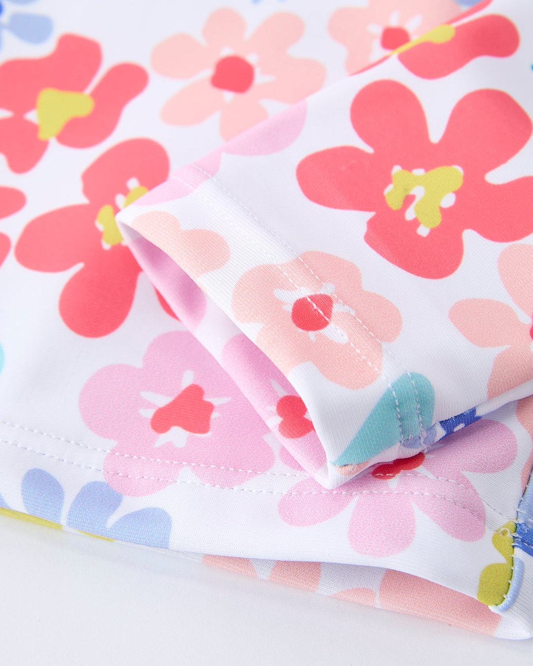 Floral-patterned fabric with pink and red flowers on a white background